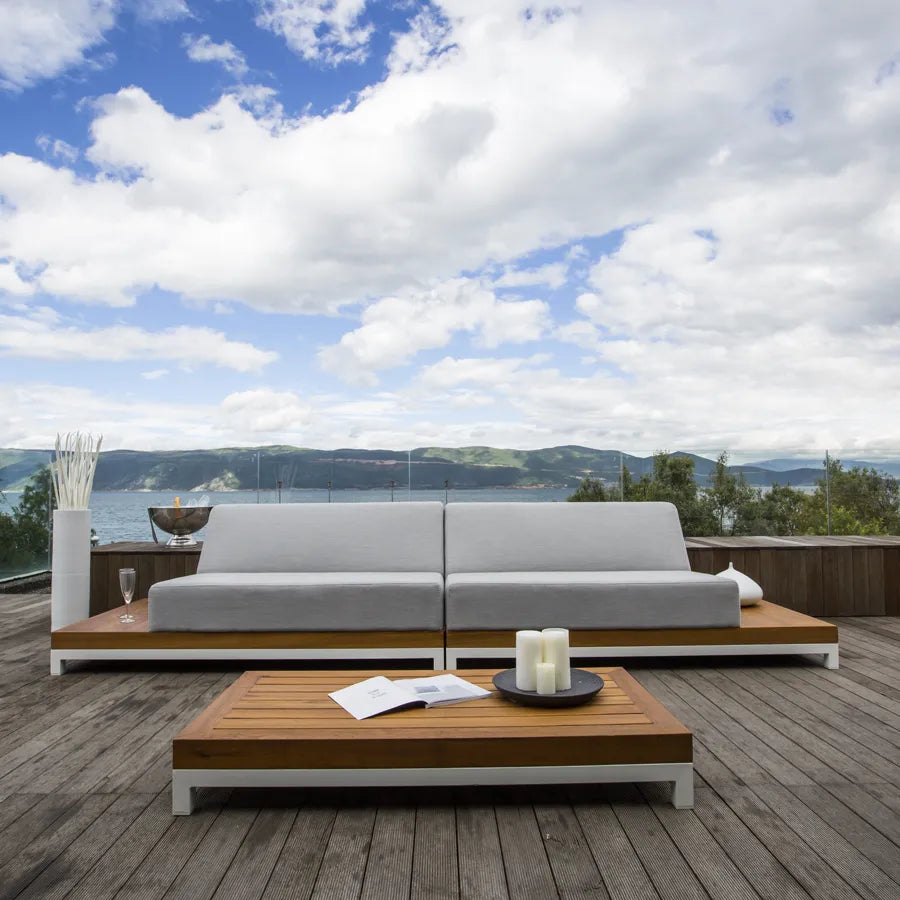 Set Ivory s bijelim postoljem i jastucima boje olova na terasi s oblacima u pozadini