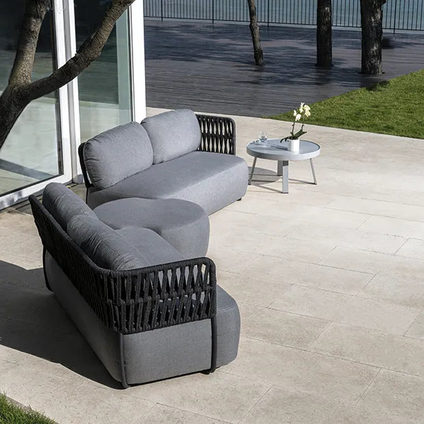 Set Soft Modular s crnim postoljem i tamnosivim užetom na terasi uz vrt, bočni prikaz